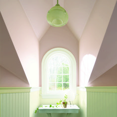 a bathroom with a sink, window and green tile on the floor in front of it