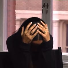 a woman covering her face with both hands