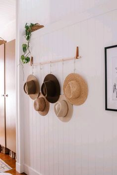 hats are hanging on the wall with hooks