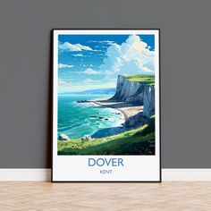 a poster hanging on the wall next to a wooden floor with an ocean and cliffs in the background