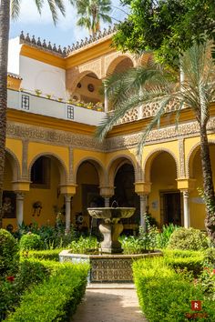 an ornate courtyard with a fountain surrounded by greenery