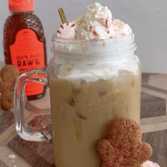 there is a drink with whipped cream and cookies in the jar on the table next to it