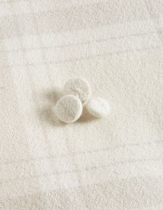 three small white balls on top of a blanket