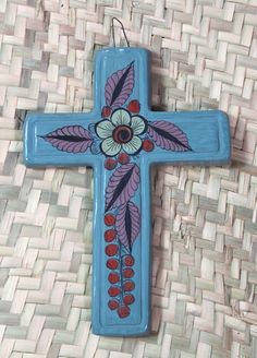 a blue cross with flowers painted on it