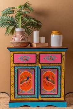 a colorful painted cabinet with two birds on it