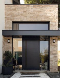 the front entrance to a modern home with black and white accents on the door mat