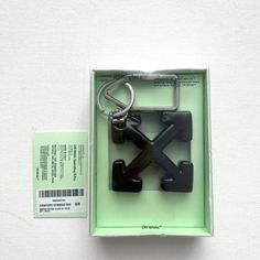 a pair of scissors in a box with a keychain