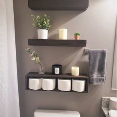 a bathroom with two shelves above the toilet