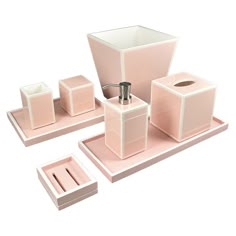 a pink bathroom set with soap dispenser, toothbrush holder and other items