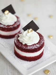 two red velvet cakes with white frosting on a plate