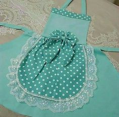 two aprons with white polka dots on them, one is blue and the other is green