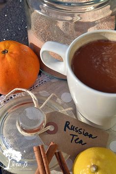 a cup of hot chocolate next to two oranges and cinnamon sticks