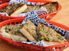 three red baskets filled with food on top of a wooden table