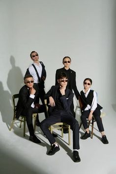 a group of men in suits and sunglasses posing for a photo