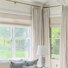 a living room filled with lots of furniture next to a window covered in drapes