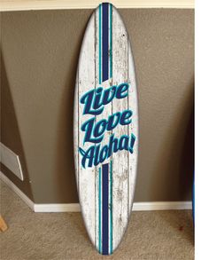 a white surfboard with the words live love aloha written in blue on it