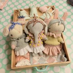 three stuffed animals in a wooden box on a table