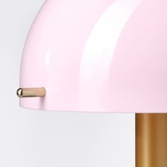 a pink and gold table lamp on a white background