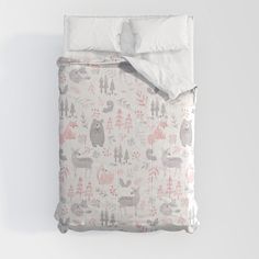 an unmade bed with pink and grey woodland animals on the sheets, next to a white pillow