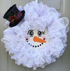 a white wreath with a snowman face on it