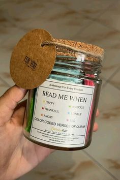 a hand holding a jar filled with colored pencils next to a tag that says read me when