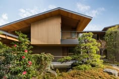 the house is made out of wood and has a sloping roof over it's garden area