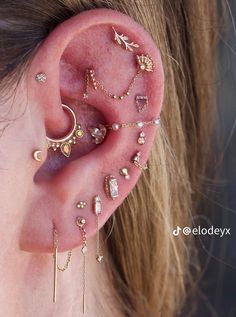 a woman wearing ear piercings with different designs