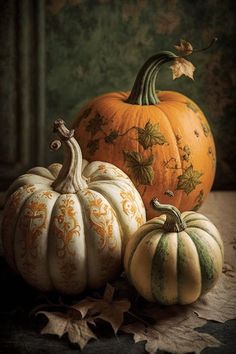 three pumpkins sitting next to each other on a table