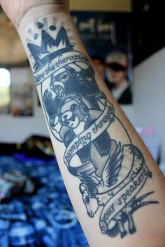 a person with a tattoo on their arm that has a crown and some words on it