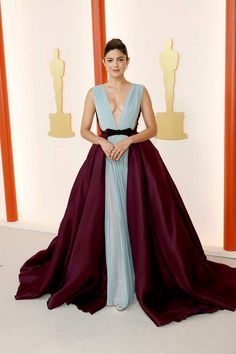 a woman in a blue and purple dress posing for the camera at an oscars event