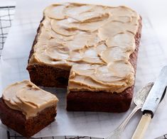 there is a cake with frosting on it and two forks next to the cake