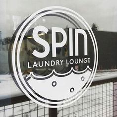 the logo for a laundry lounge is seen through a window