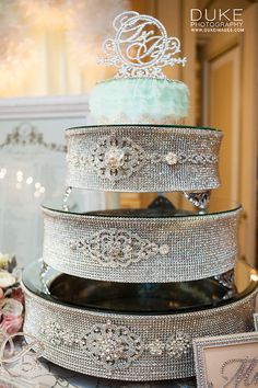 a three tiered wedding cake is adorned with swaroons and diapaste