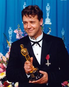 a man in a tuxedo holding an award