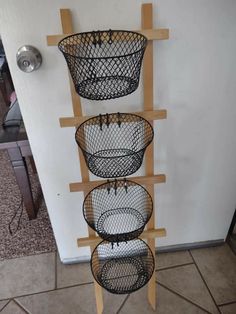 three metal baskets are hanging on the wall