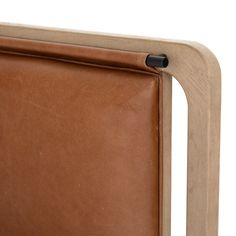 a close up of a brown leather headboard on a wooden frame with black handles