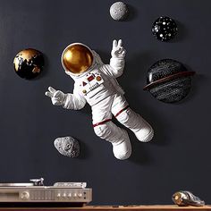 an astronaut floating in the air surrounded by planets and other objects on a black wall