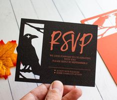 a person holding up a black and orange card with the word rsp on it