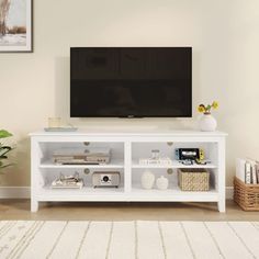 a flat screen tv sitting on top of a white entertainment center in a living room