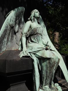 a statue of an angel sitting on top of a bench