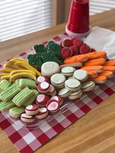 a table topped with lots of different types of cookies on top of a red and white checkered table cloth