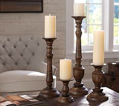 candles are lined up on a table in front of a window