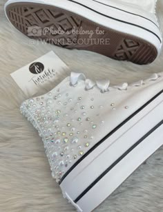 a pair of white sneakers with lots of swarong on the soles are shown