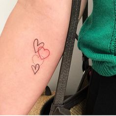 two hearts tattoo on the right arm and left arm, with dots in between them