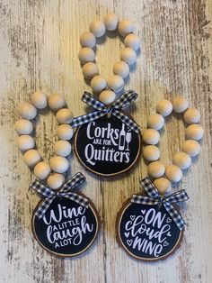 three cookies decorated with black and white plaid ribbon are sitting next to each other on a wooden table