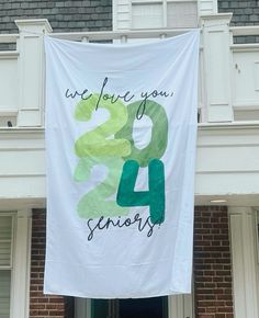 a banner hanging from the side of a building that says we love you 24 seniors