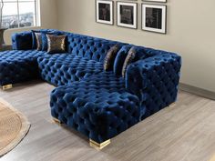 a large blue couch sitting on top of a hard wood floor next to a window