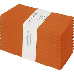 a stack of orange napkins with a white ribbon