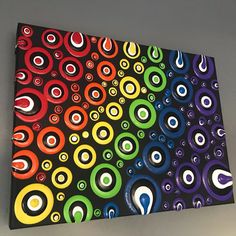 an abstract painting on canvas with circles and spirals in black, red, green, blue, yellow