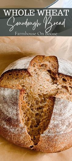 a loaf of whole wheat sourdough bread sitting on top of a piece of parchment paper